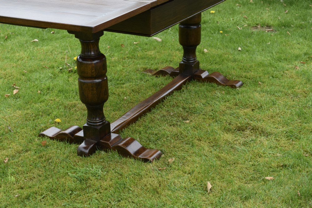 An early 20th-century dark oak refectory dining table featuring turned bulbous legs, a low central stretcher, and a rectangular wooden top. View XI