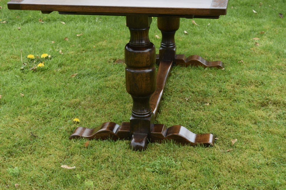 An early 20th-century dark oak refectory dining table featuring turned bulbous legs, a low central stretcher, and a rectangular wooden top. View XII