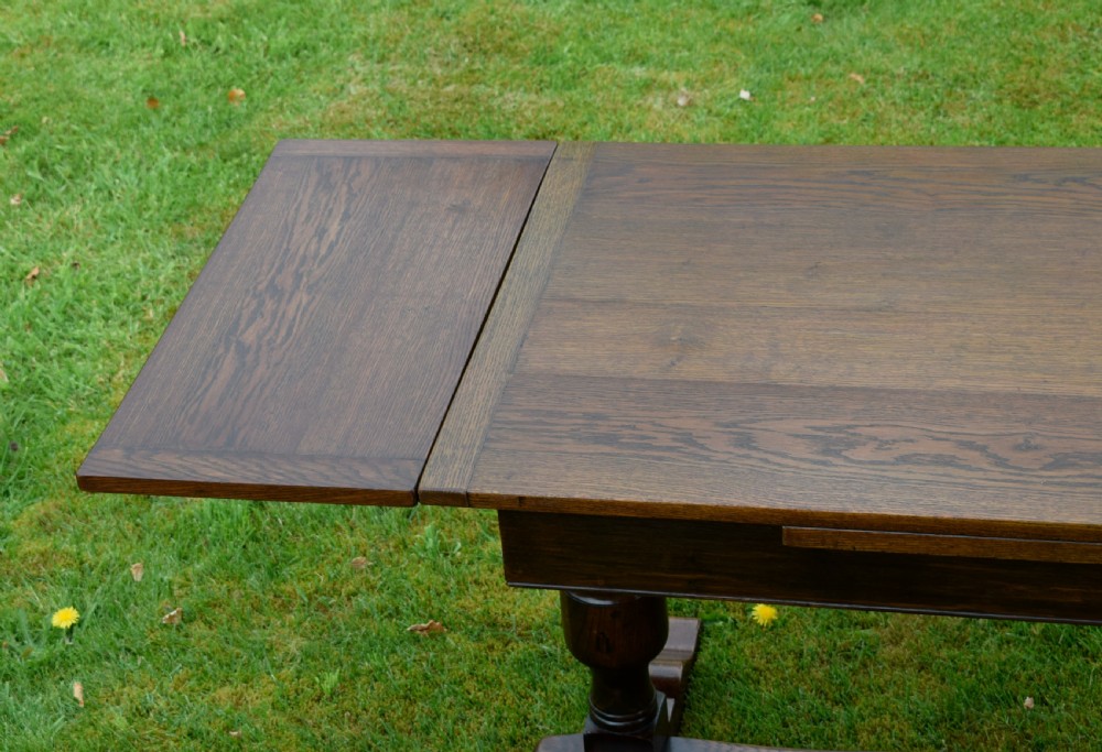 An early 20th-century dark oak refectory dining table featuring turned bulbous legs, a low central stretcher, and a rectangular wooden top. View XIII