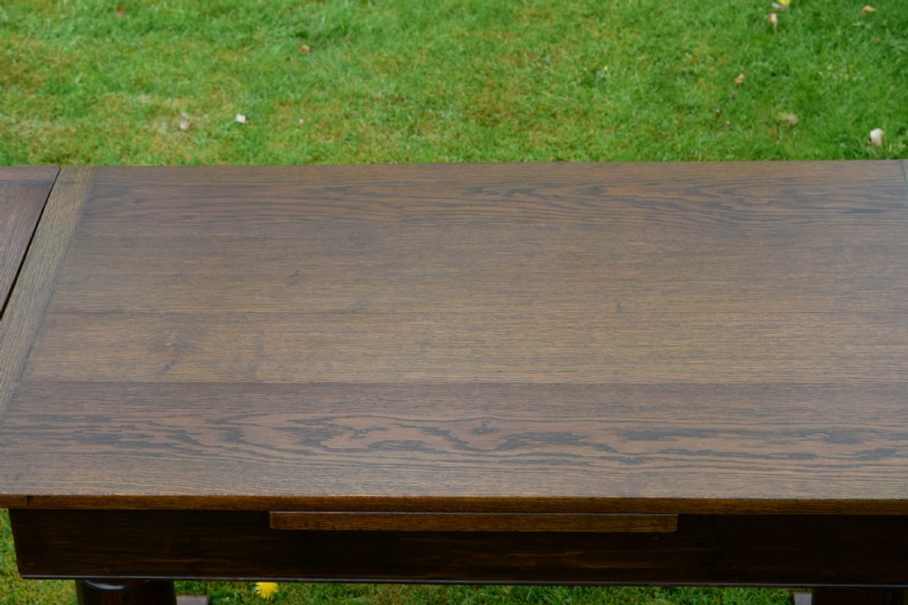 An early 20th-century dark oak refectory dining table featuring turned bulbous legs, a low central stretcher, and a rectangular wooden top. View XIV