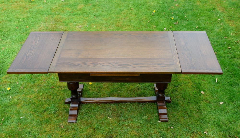 An early 20th-century dark oak refectory dining table featuring turned bulbous legs, a low central stretcher, and a rectangular wooden top. View XVI