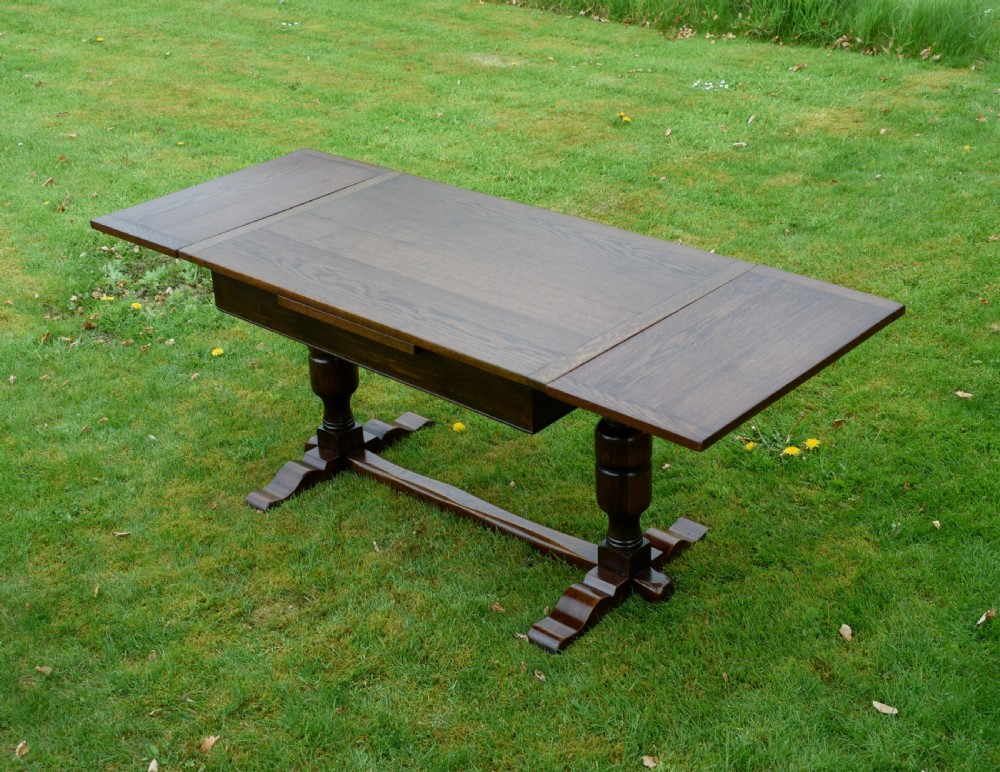 An early 20th-century dark oak refectory dining table featuring turned bulbous legs, a low central stretcher, and a rectangular wooden top. View XVII