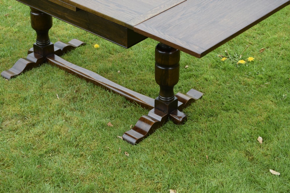 An early 20th-century dark oak refectory dining table featuring turned bulbous legs, a low central stretcher, and a rectangular wooden top. View XVIII
