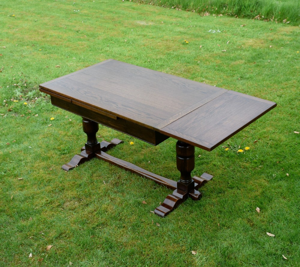 An early 20th-century dark oak refectory dining table featuring turned bulbous legs, a low central stretcher, and a rectangular wooden top. View XIX