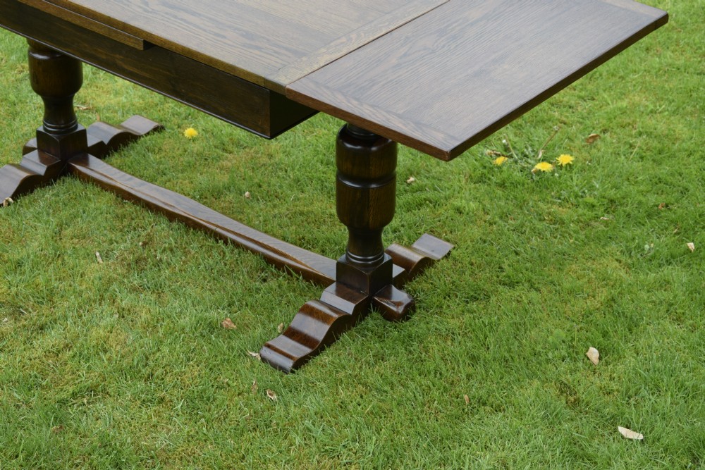 An early 20th-century dark oak refectory dining table featuring turned bulbous legs, a low central stretcher, and a rectangular wooden top. View XXI