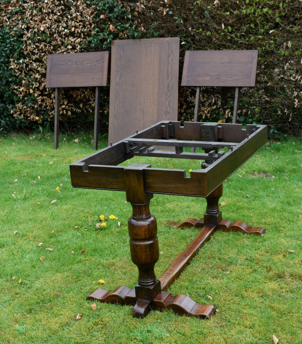An early 20th-century dark oak refectory dining table featuring turned bulbous legs, a low central stretcher, and a rectangular wooden top. View XXV