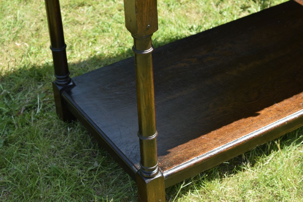 A dark oak Welsh dresser featuring an upper open plate rack with three shelves and a lower base with four drawers supported by turned legs and a bottom shelf. View XVII