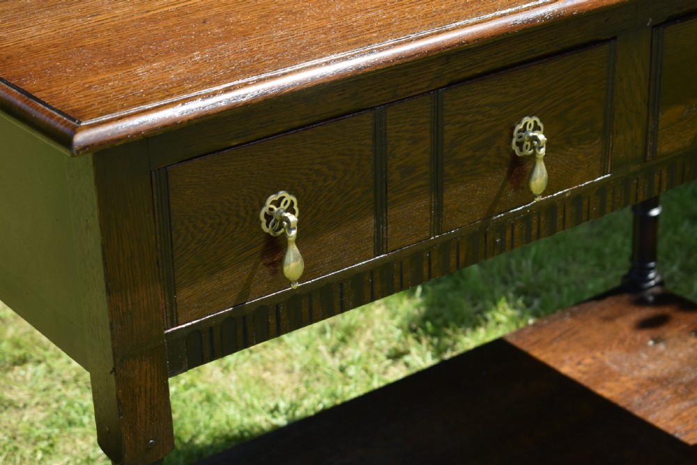 A dark oak Welsh dresser featuring an upper open plate rack with three shelves and a lower base with four drawers supported by turned legs and a bottom shelf. View XVIII