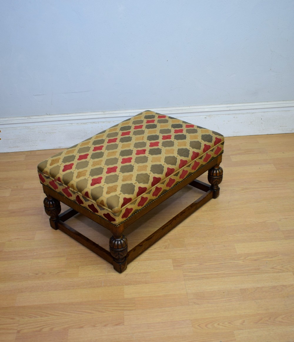 An antique carved oak stool with a geometric patterned upholstered seat, turned legs, and a perimeter wood stretcher. View VIII