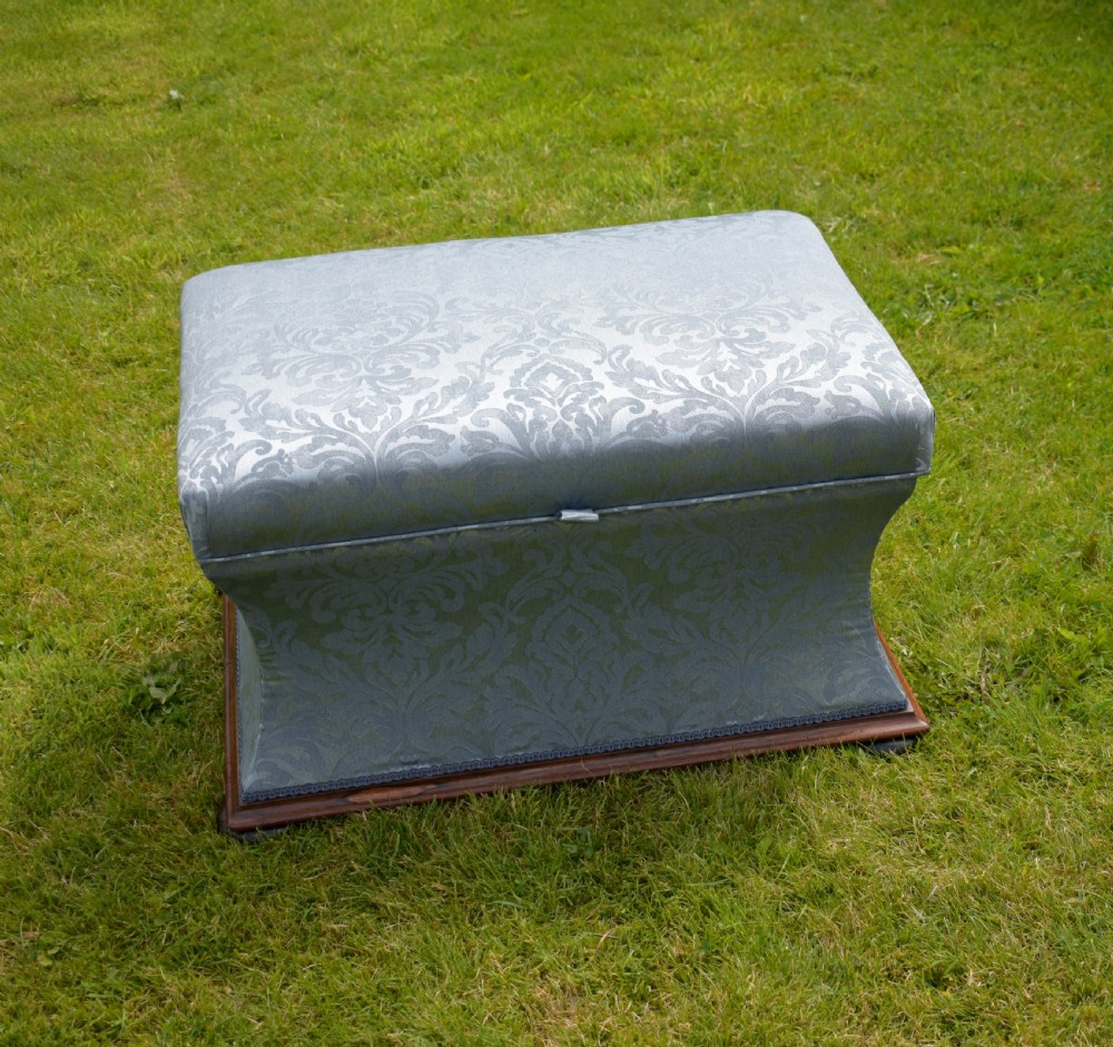 A Regency sarcophagus-shaped ottoman upholstered in blue and silver damask fabric set upon a rosewood plinth base. View II
