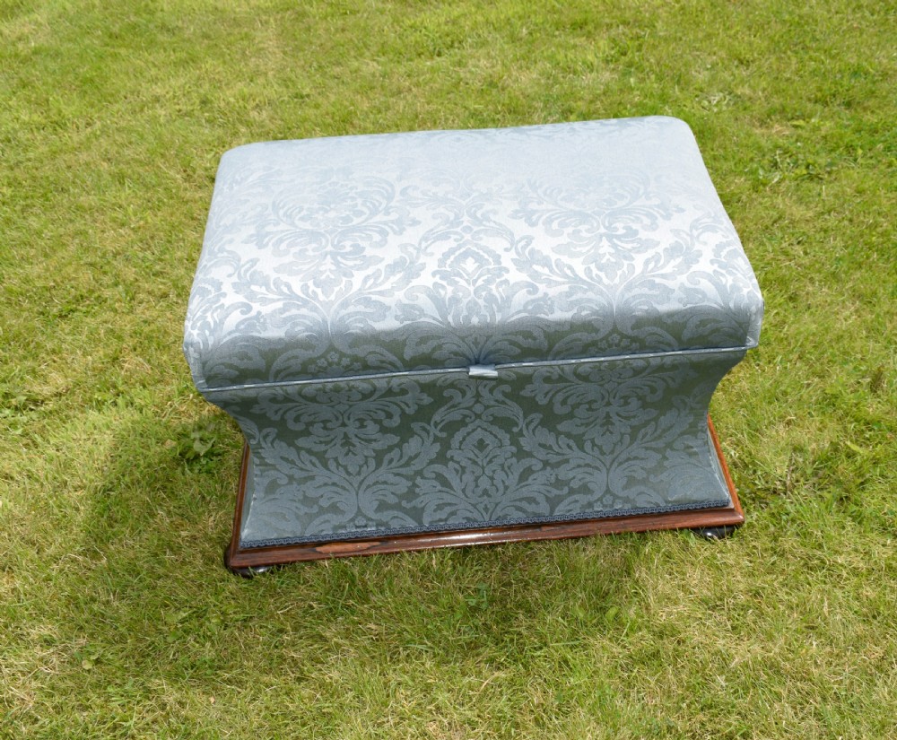 A Regency sarcophagus-shaped ottoman upholstered in blue and silver damask fabric set upon a rosewood plinth base. View V