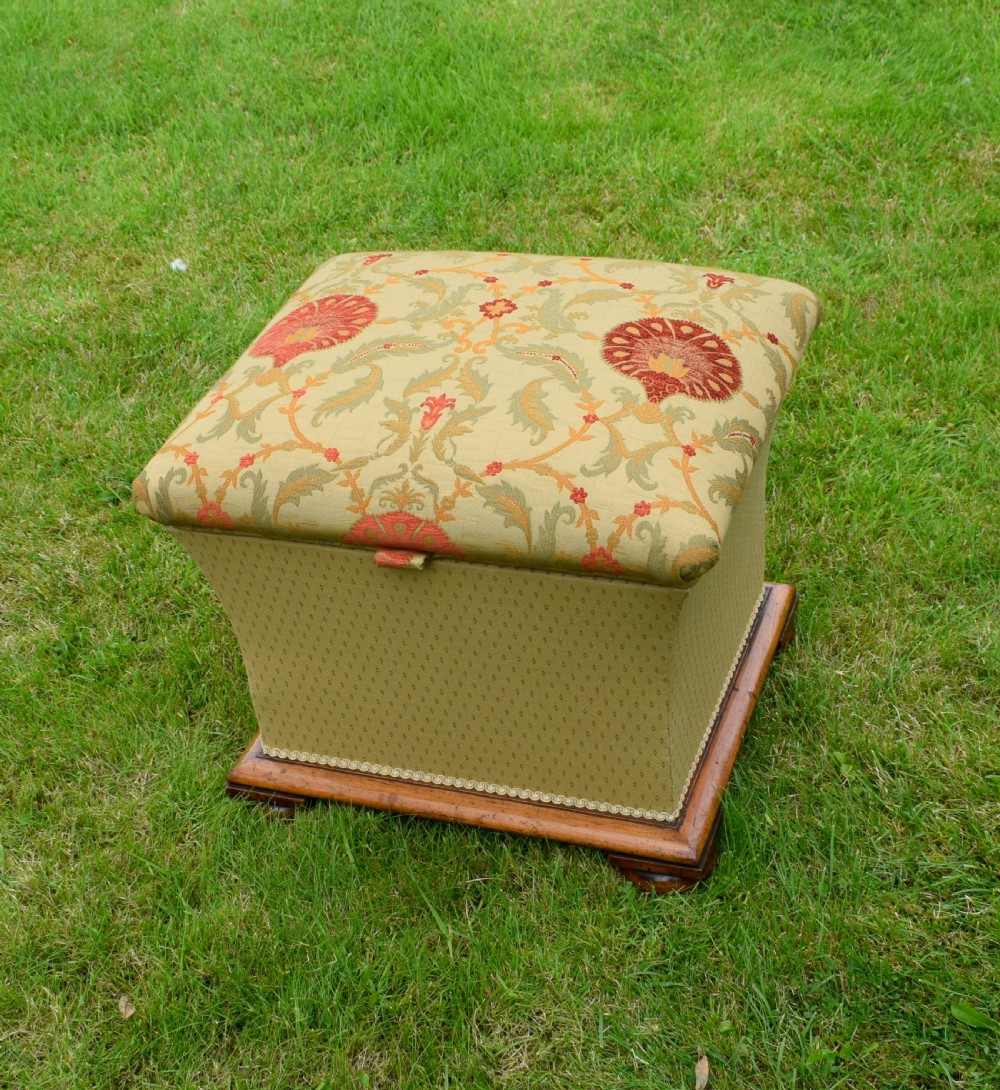 A square William IV upholstered ottoman work box featuring a gold and red floral patterned lid, flared fabric body, and a mahogany plinth base. View II