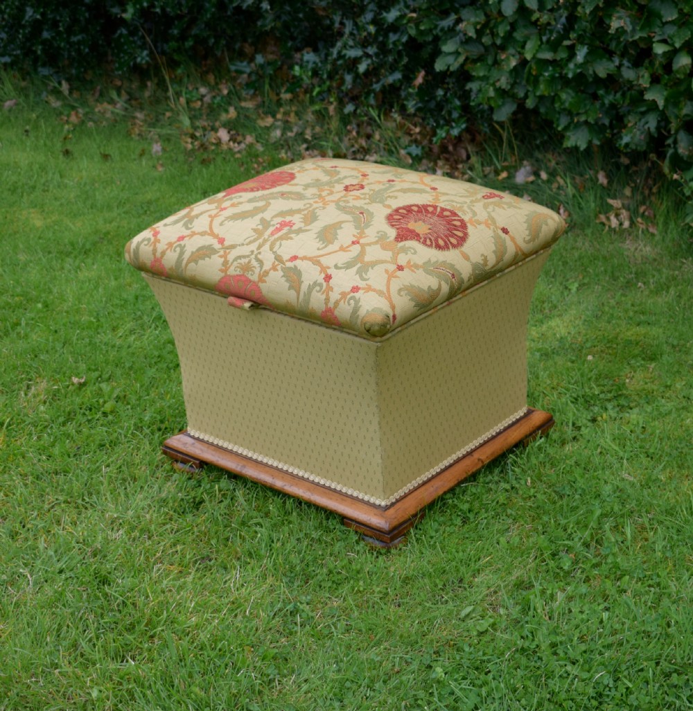 A square William IV upholstered ottoman work box featuring a gold and red floral patterned lid, flared fabric body, and a mahogany plinth base. View VIII