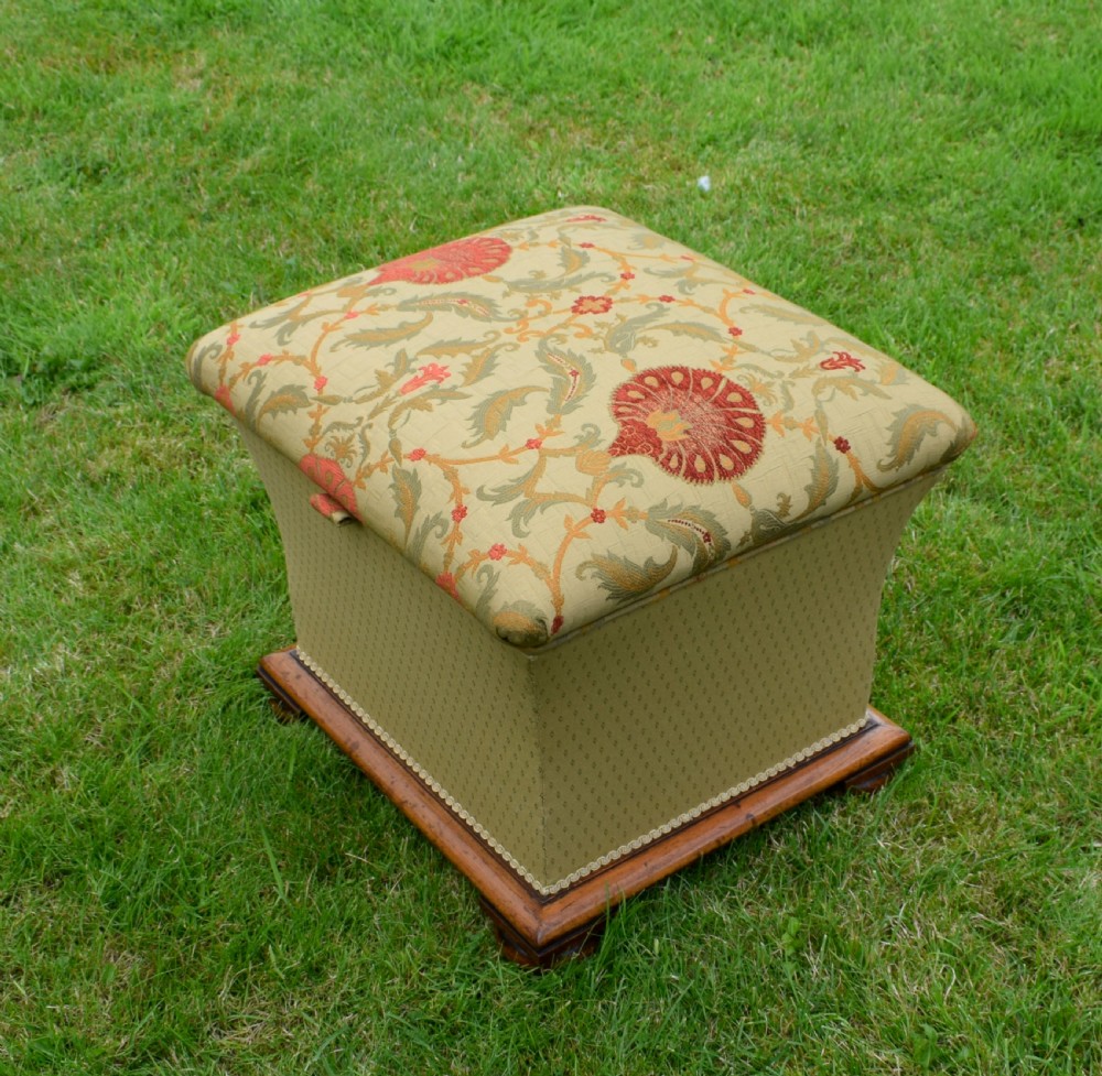 A square William IV upholstered ottoman work box featuring a gold and red floral patterned lid, flared fabric body, and a mahogany plinth base. View XVII