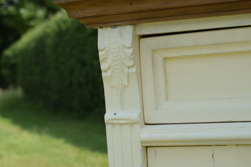 An early twentieth-century painted cream pine kitchen dresser featuring an upper shelf rack with small drawers over a two-door base cupboard. View XVII
