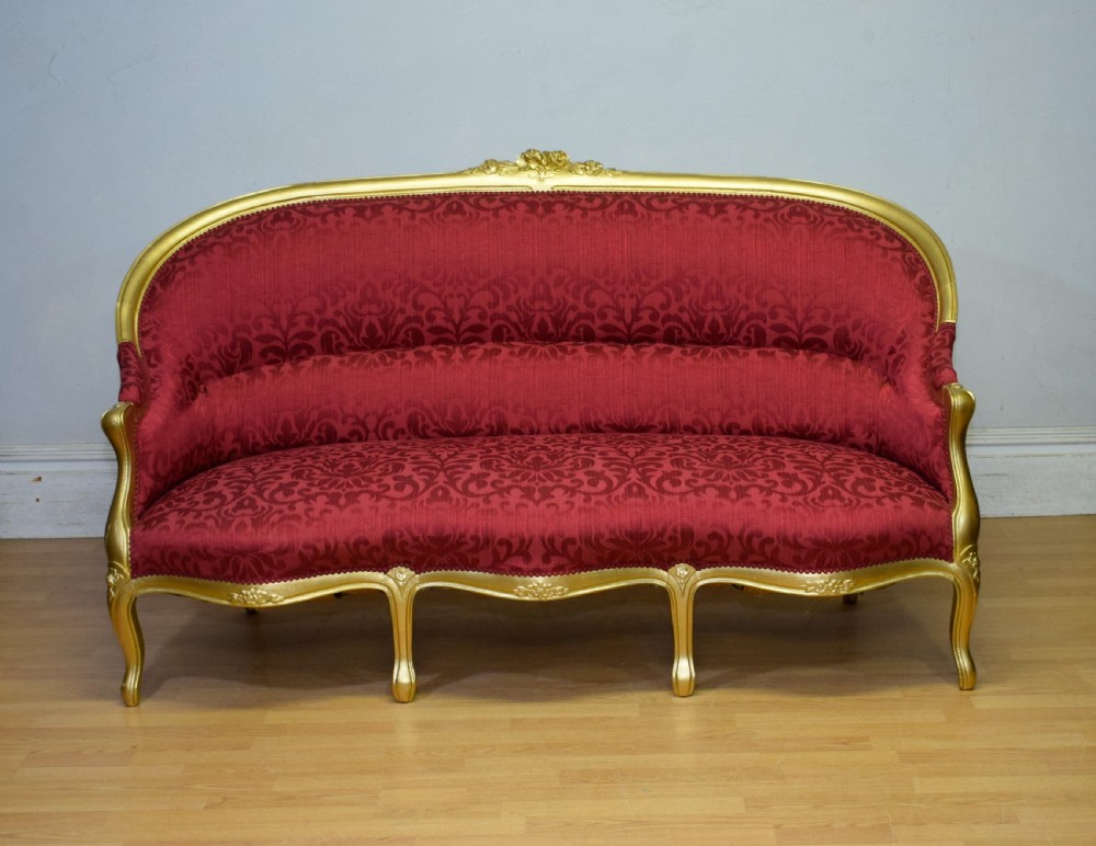 An antique French canape settee with a carved gold-gilded frame, cabriole legs, and red patterned damask upholstery. View VI