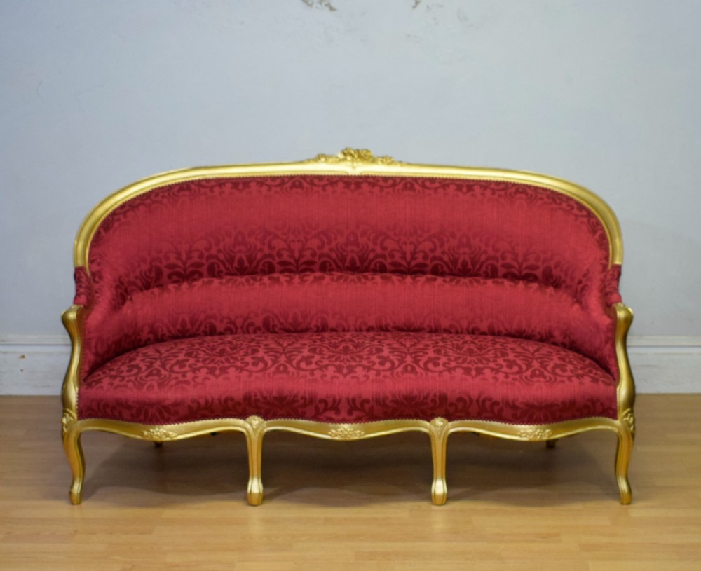 An antique French canape settee with a carved gold-gilded frame, cabriole legs, and red patterned damask upholstery. View VII