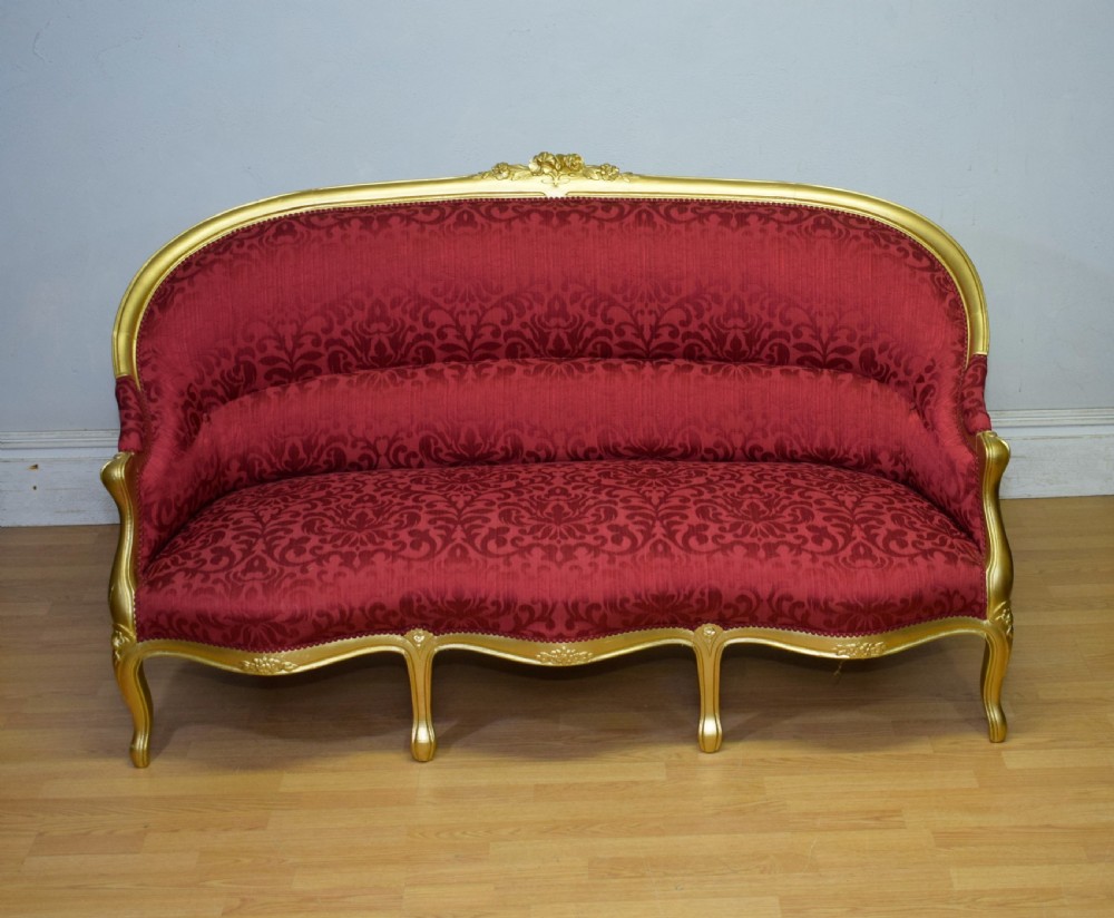 An antique French canape settee with a carved gold-gilded frame, cabriole legs, and red patterned damask upholstery. View VIII