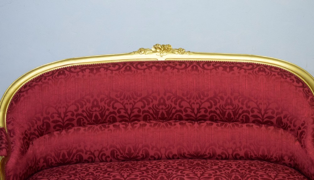 An antique French canape settee with a carved gold-gilded frame, cabriole legs, and red patterned damask upholstery. View IX