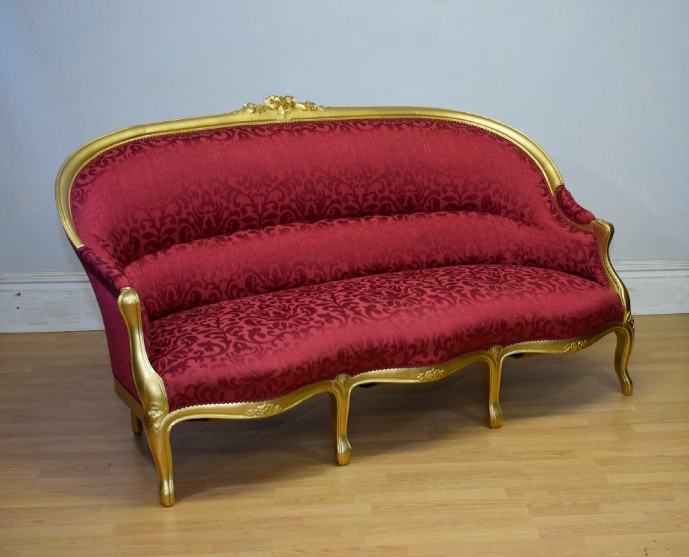 An antique French canape settee with a carved gold-gilded frame, cabriole legs, and red patterned damask upholstery. View XI