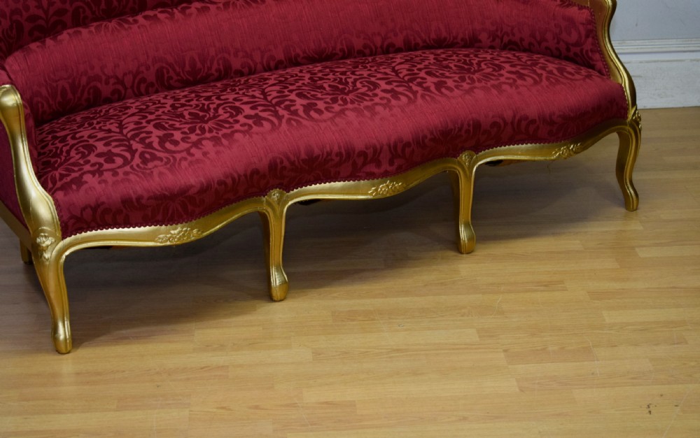 An antique French canape settee with a carved gold-gilded frame, cabriole legs, and red patterned damask upholstery. View XII