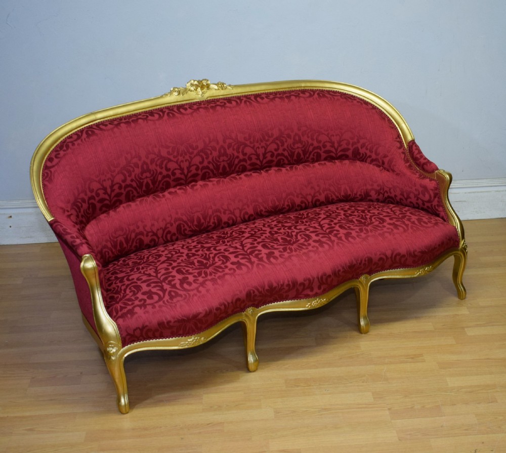 An antique French canape settee with a carved gold-gilded frame, cabriole legs, and red patterned damask upholstery. View XIV