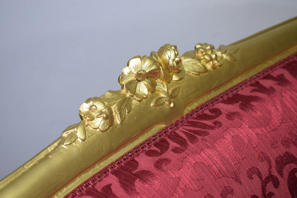 An antique French canape settee with a carved gold-gilded frame, cabriole legs, and red patterned damask upholstery. View XIX