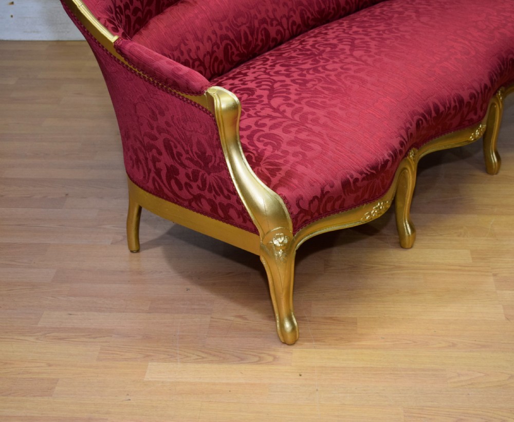 An antique French canape settee with a carved gold-gilded frame, cabriole legs, and red patterned damask upholstery. View XX