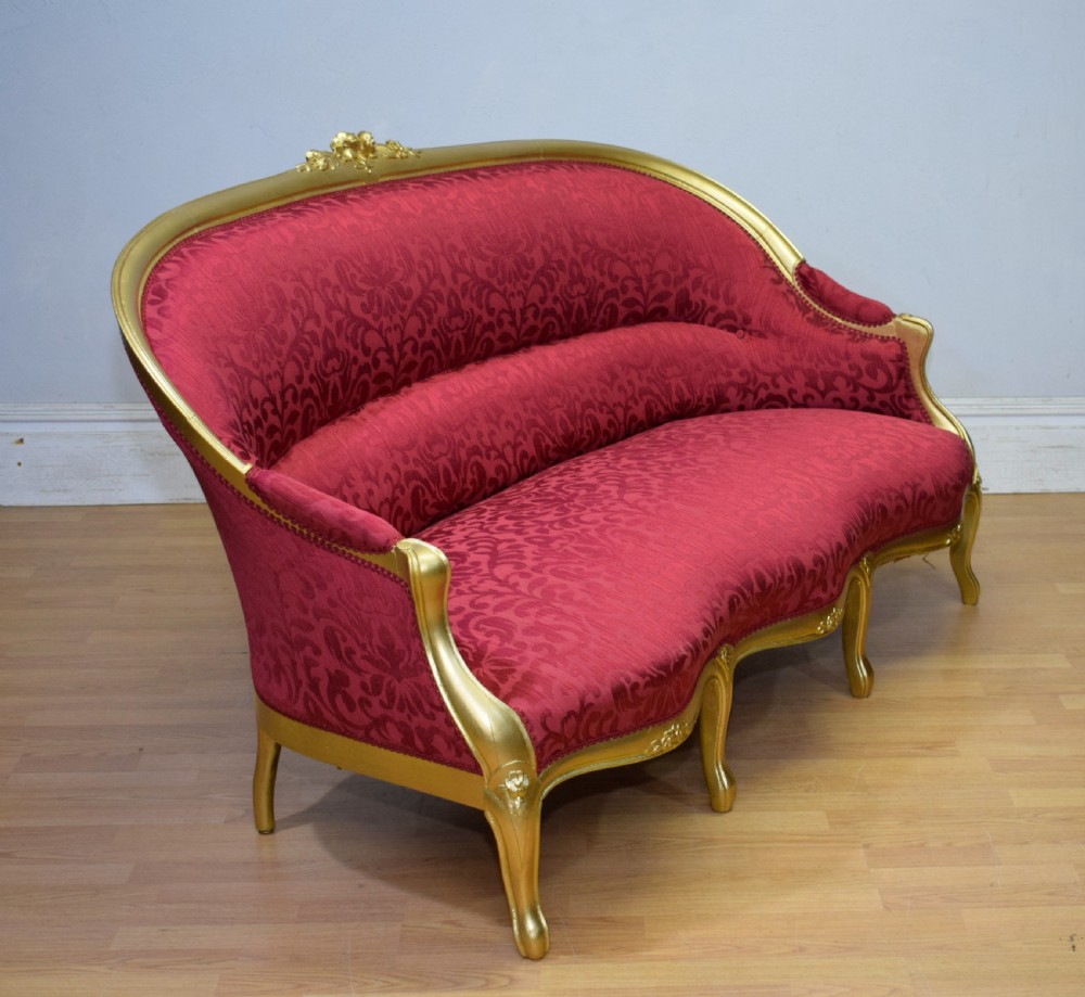 An antique French canape settee with a carved gold-gilded frame, cabriole legs, and red patterned damask upholstery. View XXI