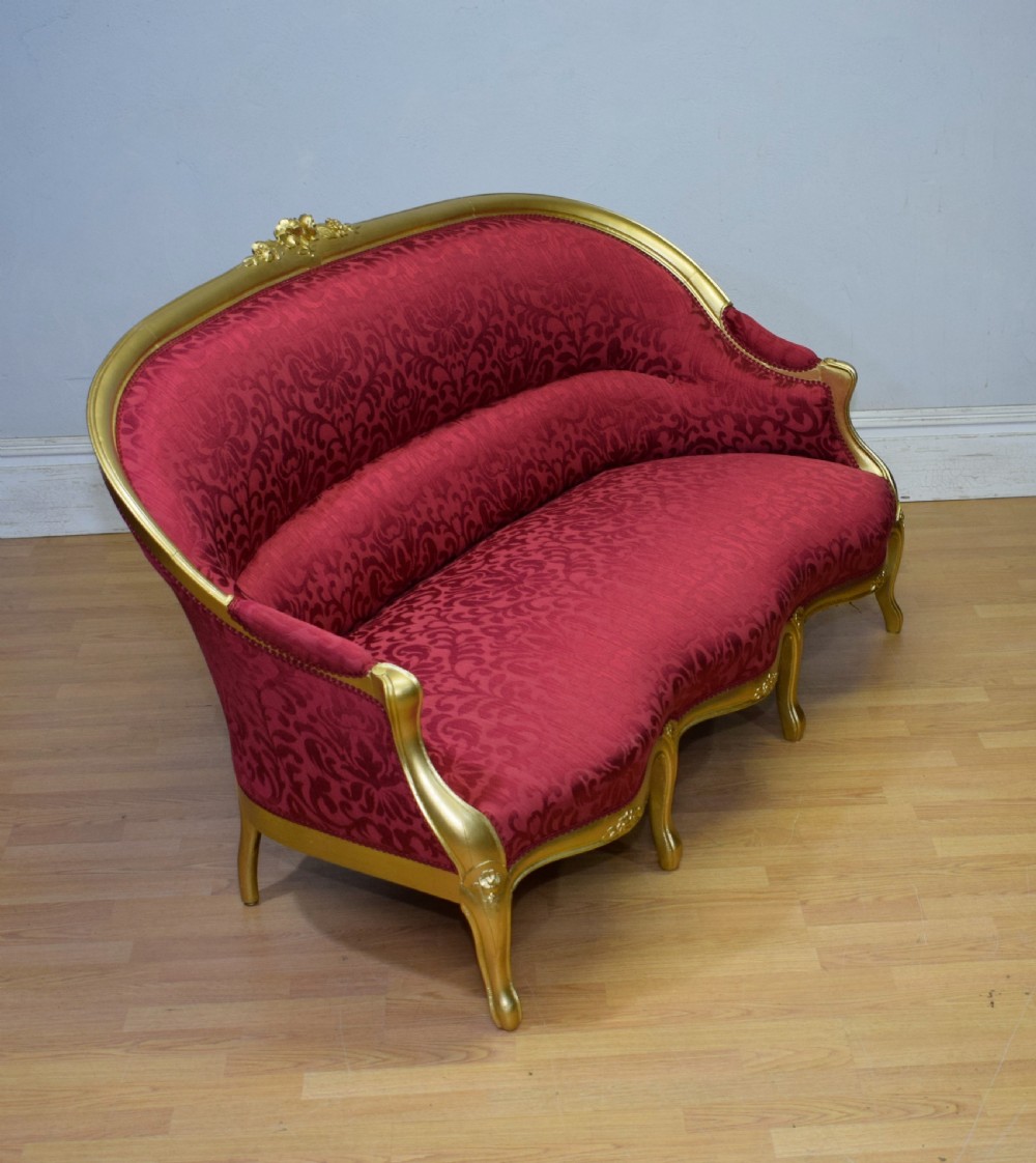 An antique French canape settee with a carved gold-gilded frame, cabriole legs, and red patterned damask upholstery. View XXII