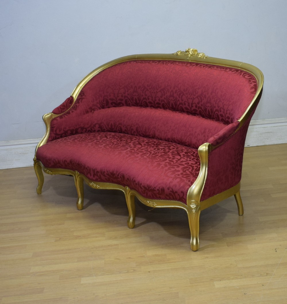 An antique French canape settee with a carved gold-gilded frame, cabriole legs, and red patterned damask upholstery. View XXV