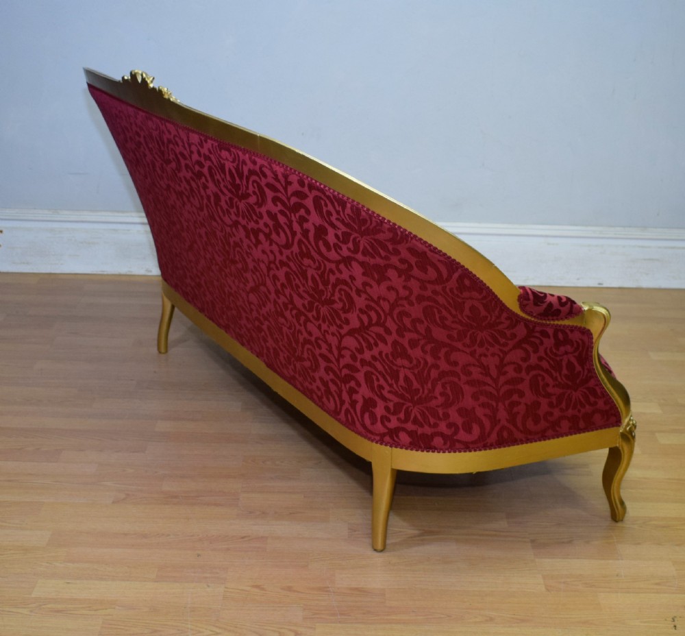 An antique French canape settee with a carved gold-gilded frame, cabriole legs, and red patterned damask upholstery. View XXIX