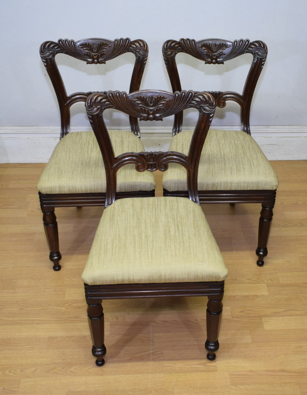 Set of three Scottish Regency mahogany dining chairs featuring carved crest rails, scrolled open backs, turned front legs, and pale green upholstered seats. View VI