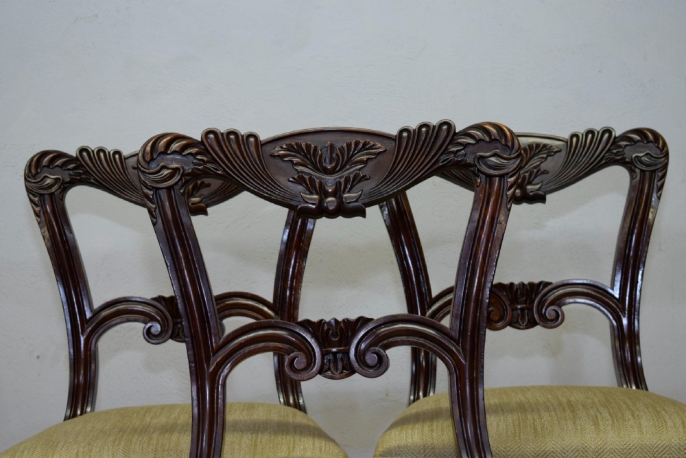 Set of three Scottish Regency mahogany dining chairs featuring carved crest rails, scrolled open backs, turned front legs, and pale green upholstered seats. View XI