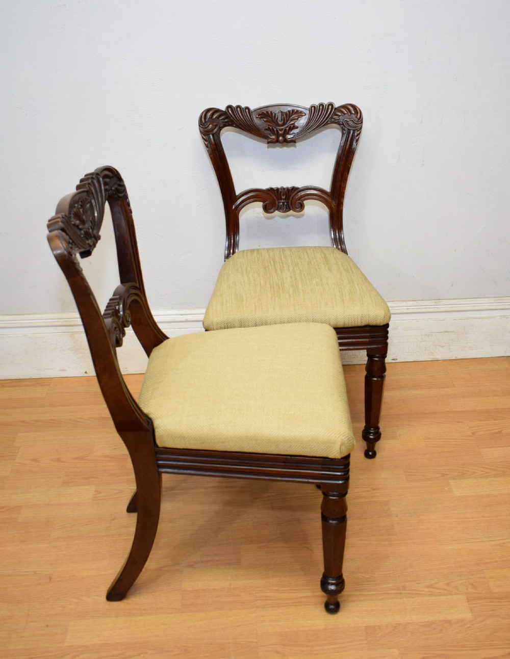 Set of three Scottish Regency mahogany dining chairs featuring carved crest rails, scrolled open backs, turned front legs, and pale green upholstered seats. View XIX