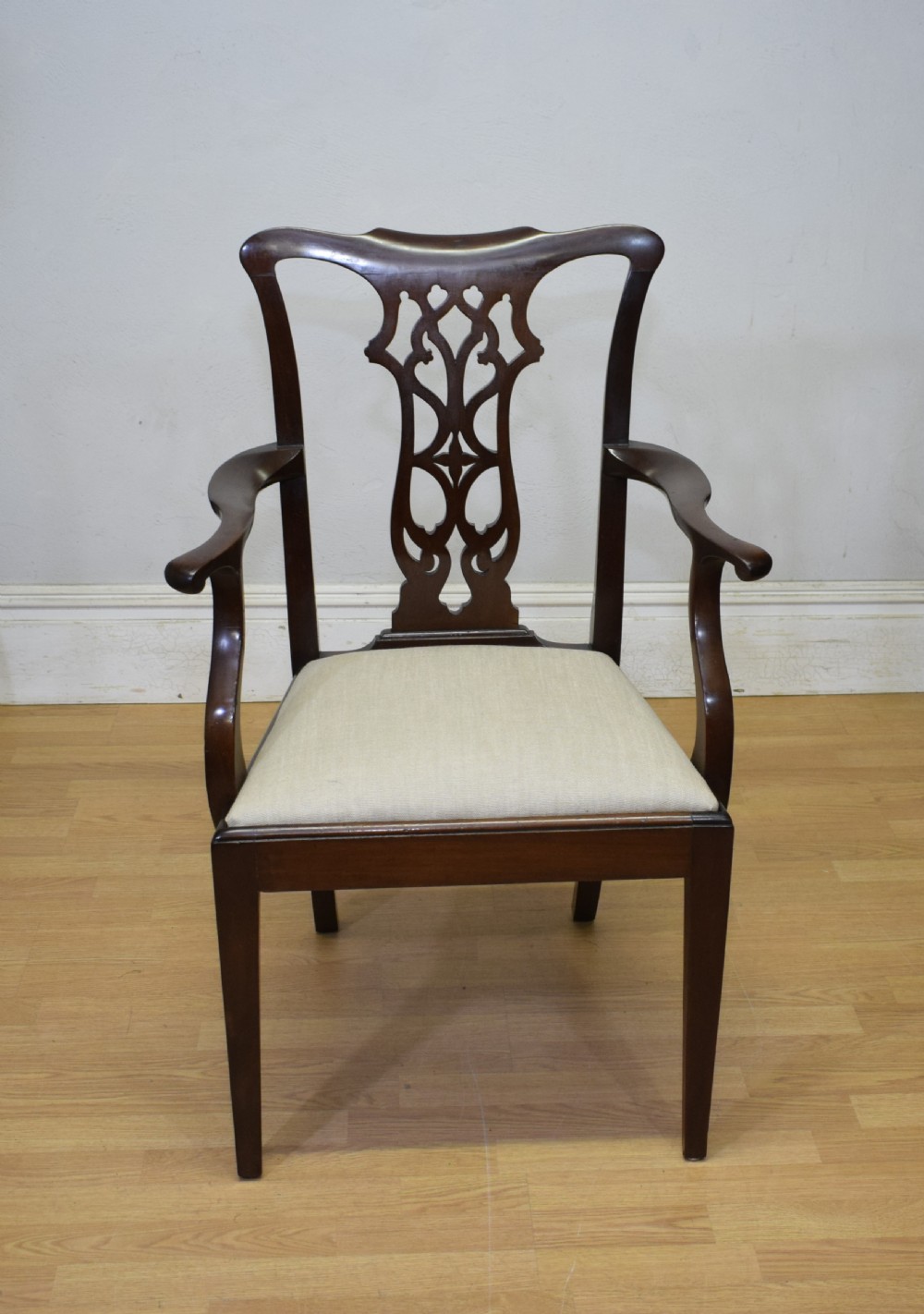 A 19th-century mahogany open armchair featuring a carved pierced back splat, curved arms, and a neutral cream upholstered seat. View III