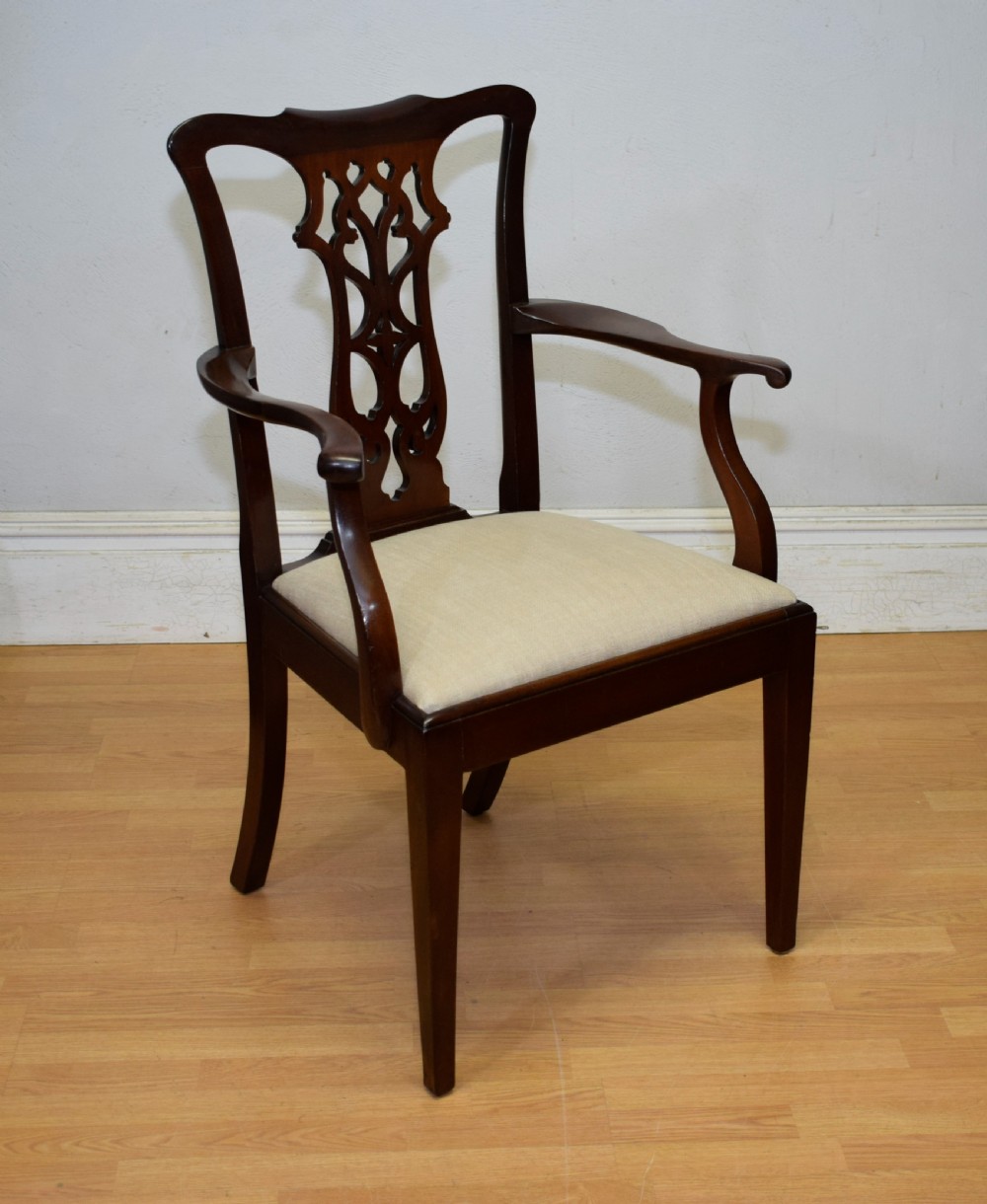A 19th-century mahogany open armchair featuring a carved pierced back splat, curved arms, and a neutral cream upholstered seat. View VIII