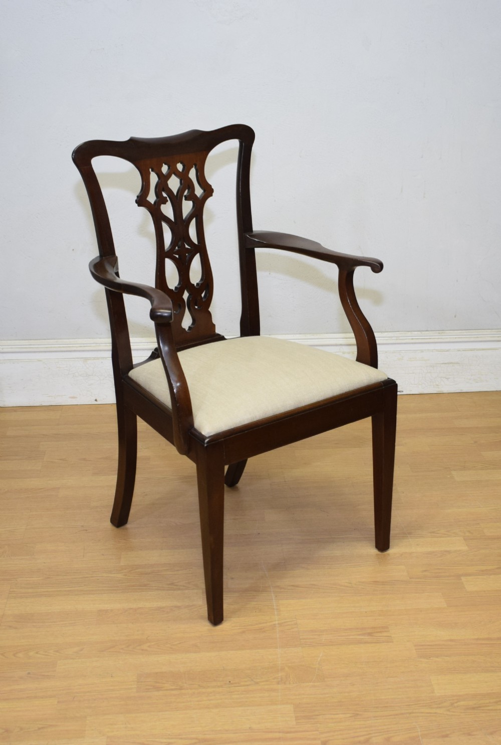 A 19th-century mahogany open armchair featuring a carved pierced back splat, curved arms, and a neutral cream upholstered seat. View IX