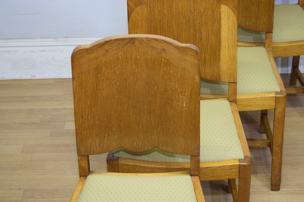 An Art Deco light oak dining suite featuring a shaped table with a central pedestal surrounded by four matching upholstered chairs. View XI