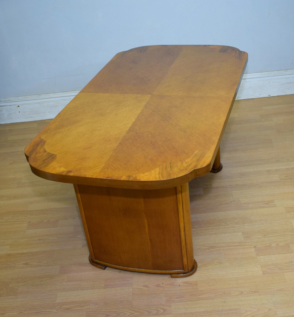 An Art Deco light oak dining suite featuring a shaped table with a central pedestal surrounded by four matching upholstered chairs. View XVIII
