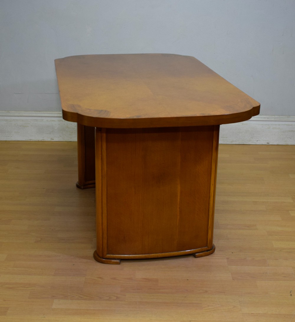 An Art Deco light oak dining suite featuring a shaped table with a central pedestal surrounded by four matching upholstered chairs. View XXI