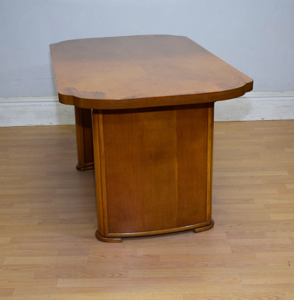 An Art Deco light oak dining suite featuring a shaped table with a central pedestal surrounded by four matching upholstered chairs. View XXII