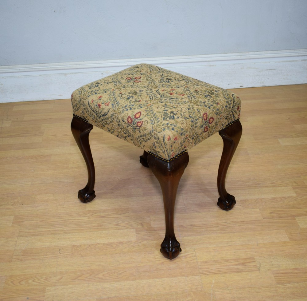 A square Chippendale style stool upholstered in floral patterned fabric with dark mahogany cabriole legs and claw-and-ball feet. View II