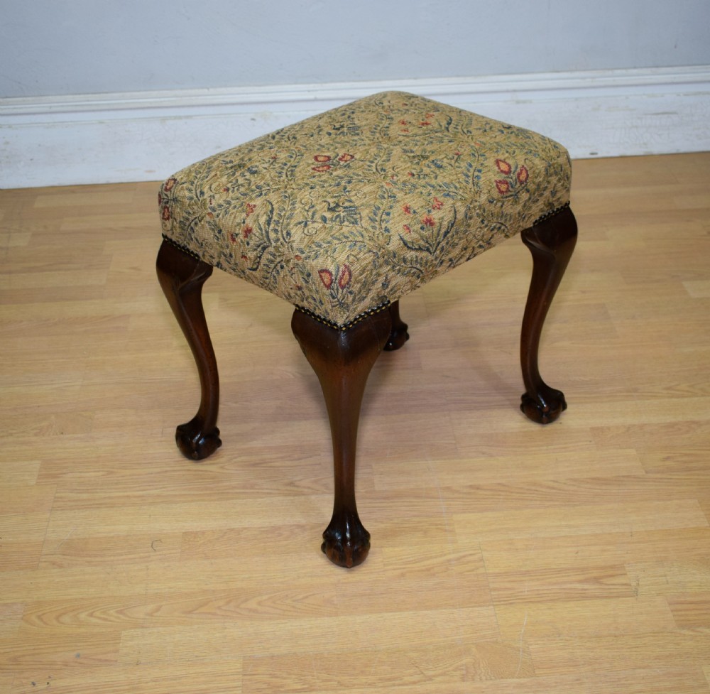 A square Chippendale style stool upholstered in floral patterned fabric with dark mahogany cabriole legs and claw-and-ball feet. View VII