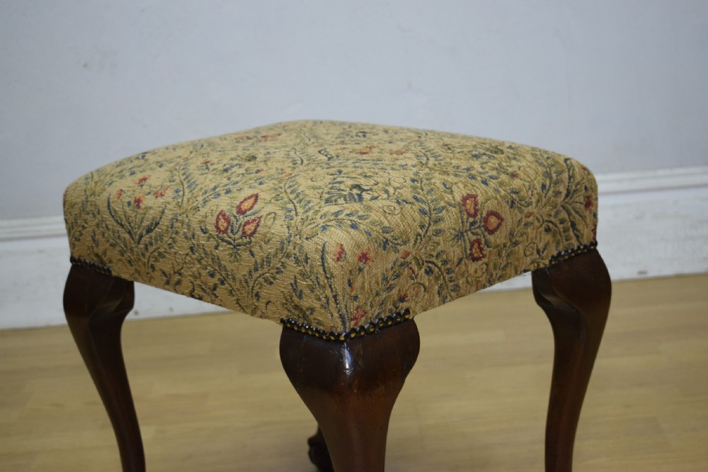 A square Chippendale style stool upholstered in floral patterned fabric with dark mahogany cabriole legs and claw-and-ball feet. View X