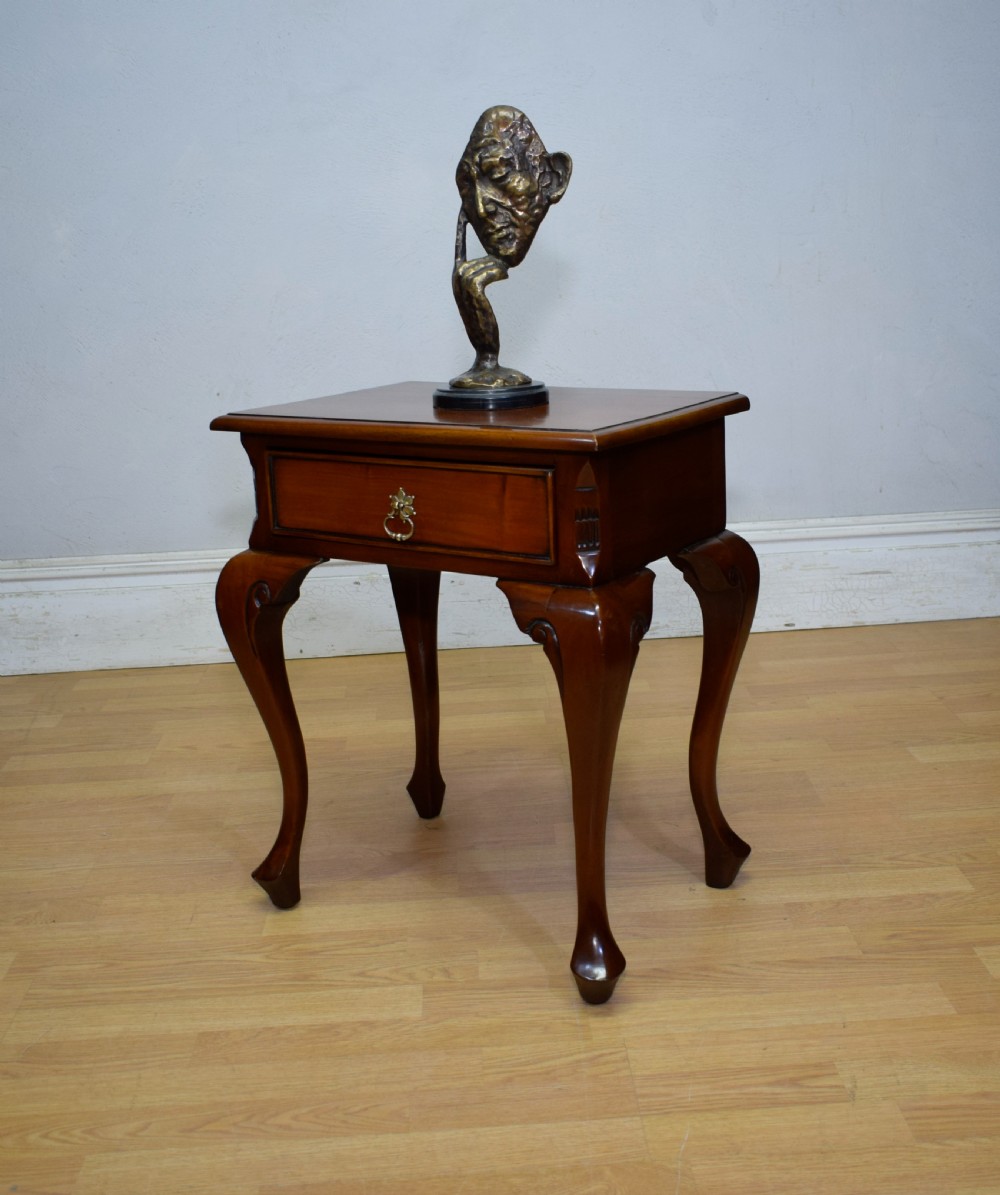 An early 20th-century mahogany lamp table featuring a single drawer with a brass drop ring handle and four cabriole legs ending in pad feet. View VII