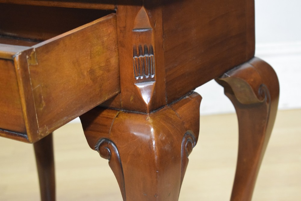 An early 20th-century mahogany lamp table featuring a single drawer with a brass drop ring handle and four cabriole legs ending in pad feet. View X