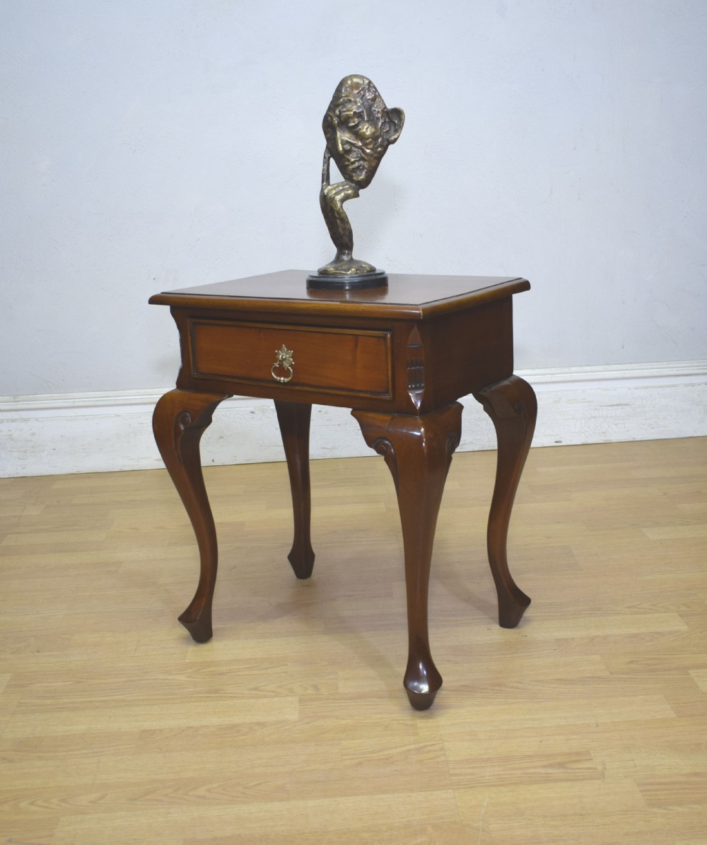 An early 20th-century mahogany lamp table featuring a single drawer with a brass drop ring handle and four cabriole legs ending in pad feet.