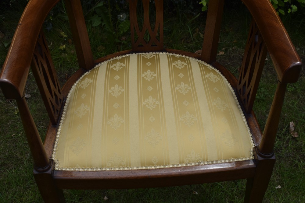 An Edwardian inlaid mahogany tub chair featuring a rounded crest rail, pierced geometric splats, and a gold striped upholstered seat. View XIII