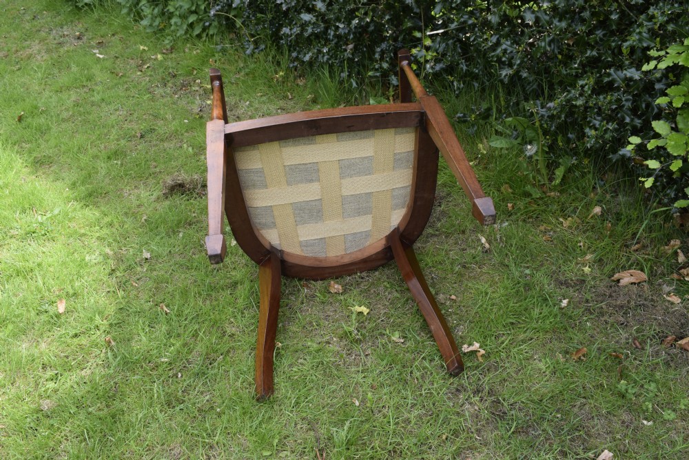 An Edwardian inlaid mahogany tub chair featuring a rounded crest rail, pierced geometric splats, and a gold striped upholstered seat. View XIV